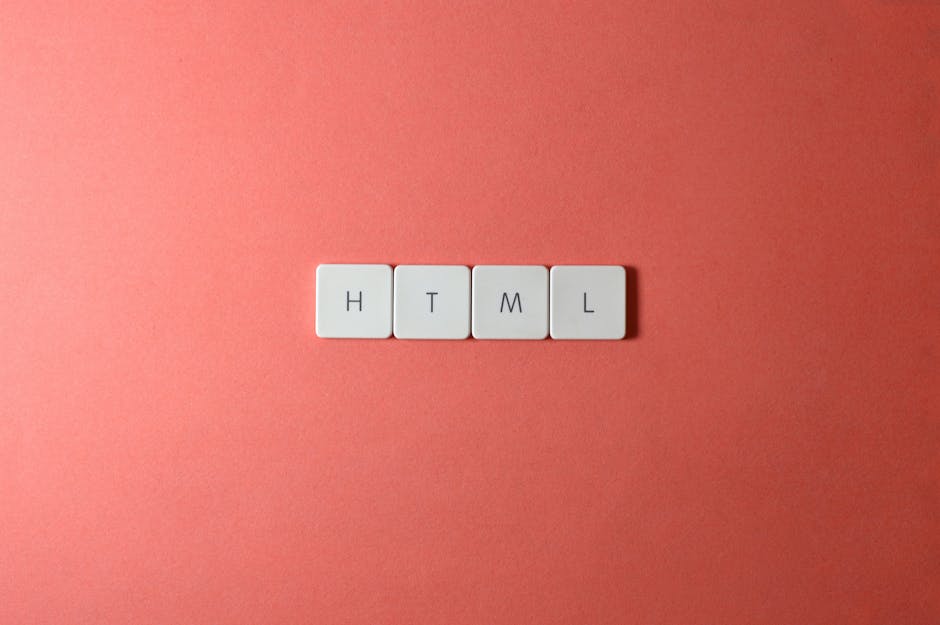 A close-up of four white square tiles with black letters spelling 'HTML' arranged in a straight line on a flat, pink background. The tiles are evenly spaced, with a clean and minimalistic appearance, 